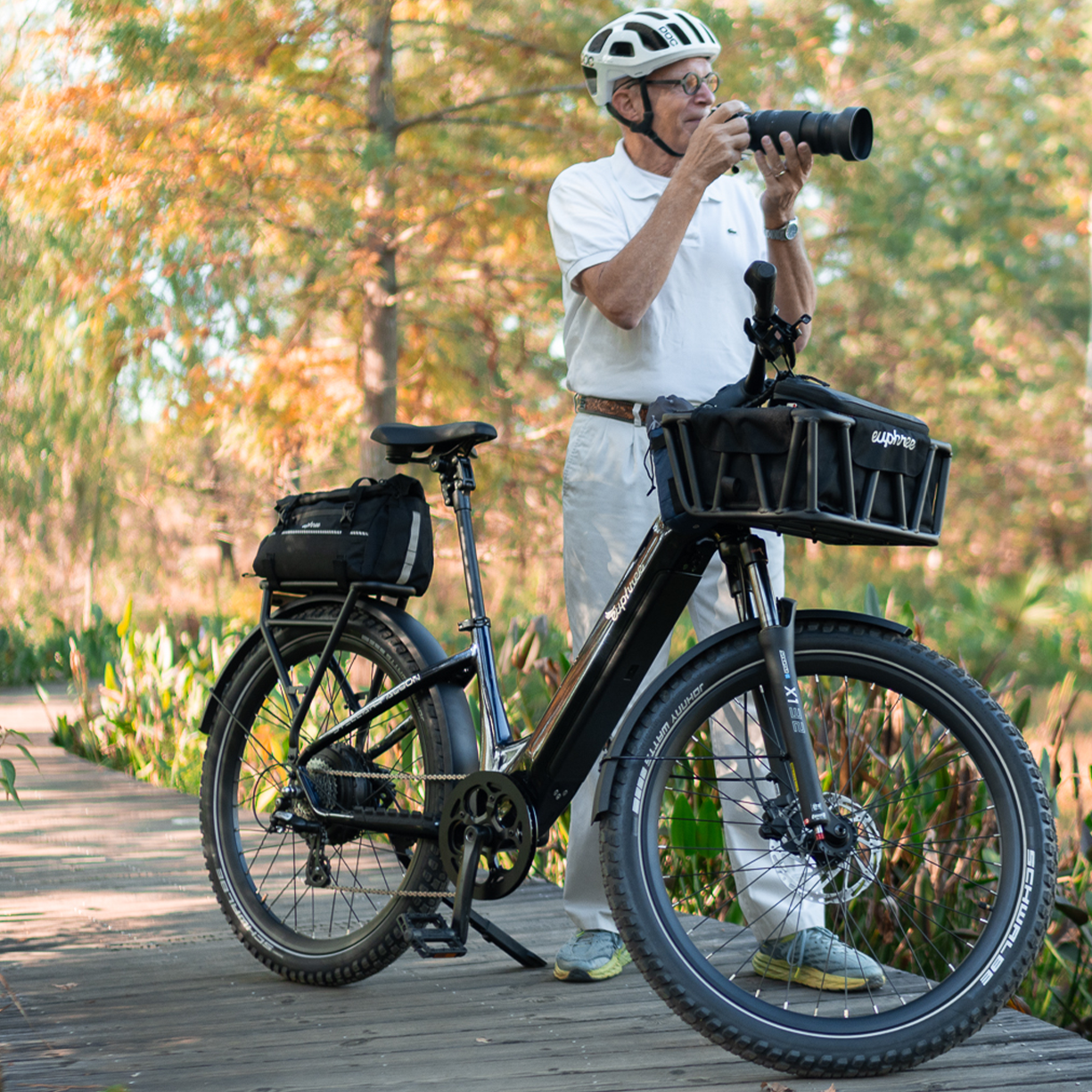 Rider standing next to Euphree Stellar Falcon step-thru in onyx black with basket liner and trunk bag