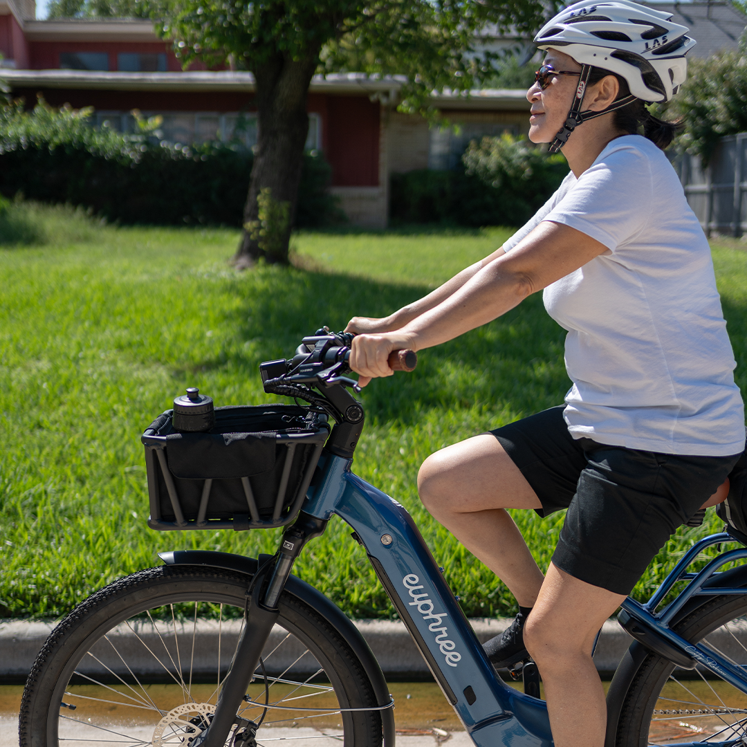 Woman riding her City Robin X+ with the Euphree Front Basket Liner attached, keeping her items safe and organized. The durable polyester liner fits the front basket perfectly and includes zippered compartments, pockets for water bottles and phones, and D-rings for extra storage security.