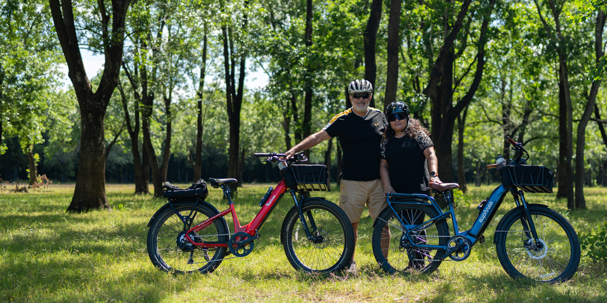 Couple posing with their Crimson Red Stellar Falcon and Rebel Blue City Robin X+ electric bikes